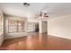 Unstaged living room with hardwood floors, a ceiling fan, and a view to the kitchen at 2893 E Cherry Hills Dr, Chandler, AZ 85249