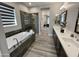 Bathroom featuring dual sinks, a soaking tub, and a glass-enclosed shower, providing a spa-like experience at 32978 N 131St Dr, Peoria, AZ 85383