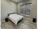 Bedroom features sleek flooring, a minimalist bed with white bedding, and stylish side tables, creating a calming atmosphere at 32978 N 131St Dr, Peoria, AZ 85383