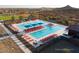 Aerial view of a community pool with lounge chairs and umbrellas, set against a scenic desert backdrop at 32978 N 131St Dr, Peoria, AZ 85383