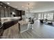 Open-concept kitchen featuring granite countertops, stainless steel appliances, and a large island with bar seating at 32978 N 131St Dr, Peoria, AZ 85383