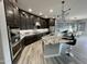 Modern kitchen featuring dark cabinetry, granite countertops, a spacious island, and stainless steel appliances at 32978 N 131St Dr, Peoria, AZ 85383