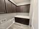 Laundry room equipped with dark cabinetry, white countertops, and modern fixtures, blending style with practical function at 32978 N 131St Dr, Peoria, AZ 85383