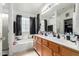Bright bathroom featuring a soaking tub, window, dual-sink vanity and a large mirror for a spa-like feel at 3418 W Maldonado Rd, Phoenix, AZ 85041