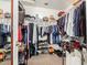 Walk-in closet well stocked with hanging clothes, shelves, shoes and carpeted floors for ample storage at 3418 W Maldonado Rd, Phoenix, AZ 85041