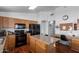 Bright kitchen featuring an island, wood cabinets, black appliances, and a convenient desk area at 3418 W Maldonado Rd, Phoenix, AZ 85041