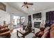 Cozy living room with a fireplace, ceiling fan, hardwood floors, and sliding glass door at 3418 W Maldonado Rd, Phoenix, AZ 85041