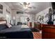 Spacious main bedroom with a ceiling fan, wood floors, and a sitting area near the window at 3418 W Maldonado Rd, Phoenix, AZ 85041