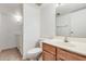 A cozy bathroom with a wood vanity, toilet, and washer and dryer at 3511 E Baseline Rd # 1085, Phoenix, AZ 85042