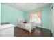 Cozy bedroom with aqua walls, hardwood floors, and a sunny window with pink curtains at 4010 E Catalina Dr, Phoenix, AZ 85018
