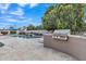 Backyard pool featuring a waterfall, patio, landscaping, and outdoor grill at 4061 E Hope St, Mesa, AZ 85205