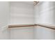 Bright, white walk-in closet with wooden clothing rods and shelves at 4061 E Hope St, Mesa, AZ 85205