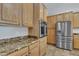 Close-up view of stainless appliances, wooden cabinets, and granite countertops in the kitchen at 4061 E Hope St, Mesa, AZ 85205