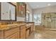 Main bathroom with dual sinks, granite counters, and a glass-enclosed shower at 4061 E Hope St, Mesa, AZ 85205