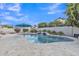 Backyard pool featuring a waterfall, pool umbrella, landscaping, and patio at 4061 E Hope St, Mesa, AZ 85205