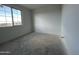 A bright, unfinished bedroom with white walls, a window, and concrete flooring at 4345 E Brook Lynn Pl, San Tan Valley, AZ 85143