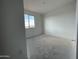 A well-lit bedroom with white walls and a large window allowing natural light at 4345 E Brook Lynn Pl, San Tan Valley, AZ 85143