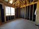 Unfinished bedroom showing exposed studs, black paper, and one window overlooking the property at 4345 E Brook Lynn Pl, San Tan Valley, AZ 85143