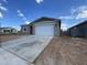 A single-story home featuring a gray stucco exterior, a two-car garage, and a long concrete driveway at 4345 E Brook Lynn Pl, San Tan Valley, AZ 85143