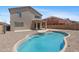 Backyard with a refreshing pool surrounded by desert landscaping and a covered patio at 43507 W Cydnee Dr, Maricopa, AZ 85138