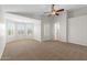 Open bedroom area with bay window, shutters, neutral paint, and ceiling fan at 43507 W Cydnee Dr, Maricopa, AZ 85138