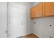 A laundry room with wood cabinets and a utility door with tiled floors at 43507 W Cydnee Dr, Maricopa, AZ 85138