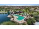 Aerial view of community pool with a lake and palm trees, perfect for relaxation at 43507 W Cydnee Dr, Maricopa, AZ 85138