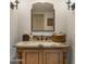 Bathroom vanity with decorative mirror, dark sconce lighting and neutral color walls at 4450 E Camelback Rd # 4, Phoenix, AZ 85018