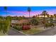 Beautiful single-story home with lush landscaping, terracotta tile roof, and desert landscape, set against a colorful sunset at 4450 E Camelback Rd # 4, Phoenix, AZ 85018