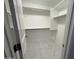 Spacious walk-in closet with custom shelving and marble tile flooring at 5338 W Wolf St, Phoenix, AZ 85031