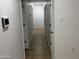 Hallway with tile floors featuring white walls, doors, and a smart home device at 5338 W Wolf St, Phoenix, AZ 85031