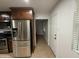 A modern stainless steel refrigerator is in the kitchen with dark brown cabinets at 5338 W Wolf St, Phoenix, AZ 85031