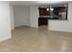 Spacious living room features neutral tile flooring and an open layout to kitchen with stainless appliances at 5338 W Wolf St, Phoenix, AZ 85031