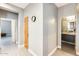 Hallway with a clock leading to the bathroom and bedroom, showcasing neutral paint and flooring at 534 W 15Th St, Tempe, AZ 85281