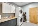 Well-lit laundry room featuring stacked washer and dryer, granite countertop, and ample shoe storage at 534 W 15Th St, Tempe, AZ 85281