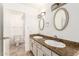 Bright bathroom featuring a double vanity with granite countertop and oval mirrors at 6873 E Kathleen Rd, Scottsdale, AZ 85254