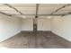 Spacious garage features cement floors and a water heater on the back wall at 6873 E Kathleen Rd, Scottsdale, AZ 85254