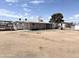 Mobile home with chain link fencing, on a lot with desert landscaping and sunny blue skies at 6950 W Karen Lee Ln, Peoria, AZ 85382