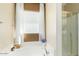 Relaxing bathroom features a large tub beneath a window and an enclosed glass shower at 7117 W Globe Ave, Phoenix, AZ 85043