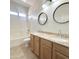 Bright bathroom features double sinks, granite countertops, and a bathtub with a shower at 7117 W Globe Ave, Phoenix, AZ 85043