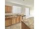 Bright kitchen features granite countertops, wood cabinets, stainless steel appliances, and a large window at 7117 W Globe Ave, Phoenix, AZ 85043