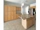 Well-lit kitchen with granite countertops, a central island, wood cabinetry, and stainless-steel appliances at 7117 W Globe Ave, Phoenix, AZ 85043