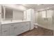 Bathroom with double sink vanity, white cabinetry, and glass shower at 7700 E Gainey Ranch Rd # 102, Scottsdale, AZ 85258
