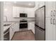 Updated kitchen with granite counters, stainless appliances, and modern white cabinets at 7700 E Gainey Ranch Rd # 102, Scottsdale, AZ 85258