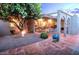 Inviting backyard patio with tile flooring, a seating area, and mature trees providing shade and privacy at 7736 E Hazelwood St, Scottsdale, AZ 85251