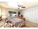 Cozy bedroom featuring a decorative bedspread, ceiling fan, and ample natural light from the window at 7736 E Hazelwood St, Scottsdale, AZ 85251