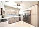Bright and airy kitchen featuring stainless steel refrigerator, white cabinets and a window above the sink at 7736 E Hazelwood St, Scottsdale, AZ 85251