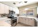 Well-lit kitchen featuring stainless steel appliances, white cabinets, and light countertops at 7736 E Hazelwood St, Scottsdale, AZ 85251