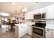 Updated kitchen with stainless steel appliances, white cabinets, and a view into the dining area at 7736 E Hazelwood St, Scottsdale, AZ 85251