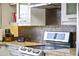 Close-up of a modern kitchen featuring stainless steel appliances, white cabinets, and tiled backsplash at 7856 E Via Marina --, Scottsdale, AZ 85258